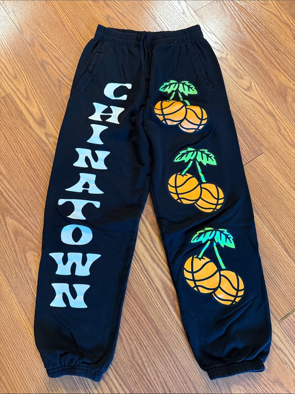 Chinatown Market men’s  Black Sweatpants with Orange basketball Graphics